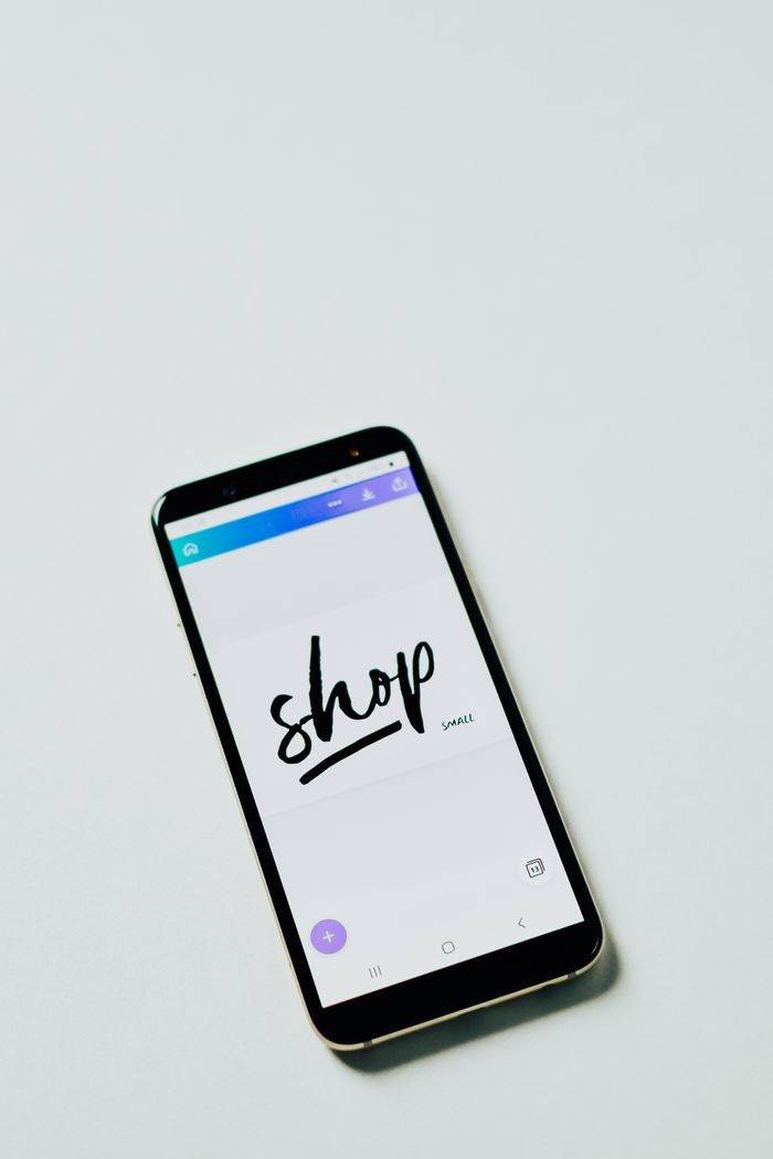 A close-up shot of a smartphone with a shopping app on a white surface, ideal for e-commerce themes.