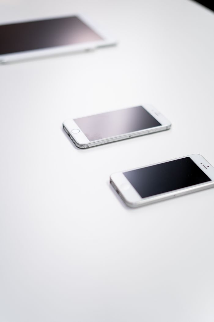 Overhead view of digital devices on a white table - ideal for tech themes.